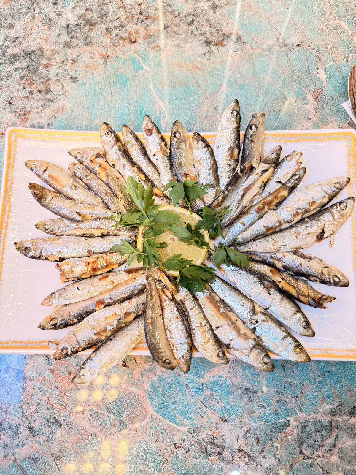 Charcoal grilled fish arranged on a platter with lemon