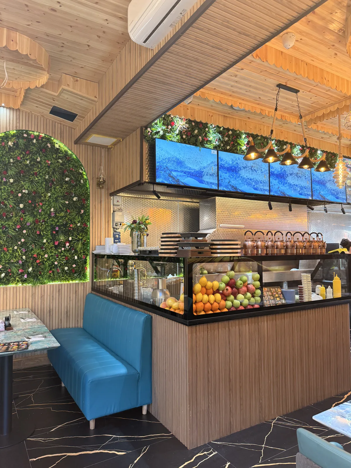 Juice counter stacked with fresh fruit and copper teapots